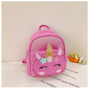 Detailed shot of pink unicorn backpack with glitter sequins on a soft cream fabric