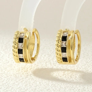 Macro shot of gold-plated hoop earrings with alternating black and white cubic zirconia stones