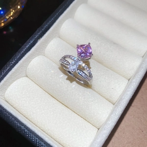 Macro detail of silver ring with pink square and pear-shaped stones in a cross-cut design