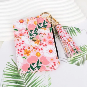Pink floral card holder with tassel pendant and keychain on white wavy display tray