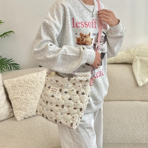 Close-up of quilted canvas crossbody bag featuring cute cartoon dog patterns and soft texture