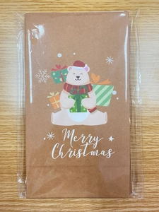 Detail of stacked Merry Christmas kraft gift bags with cute polar bear print and stickers