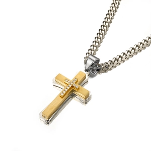 Macro detail of multi-layer cross pendant with sparkling zircons and silver cuban chain