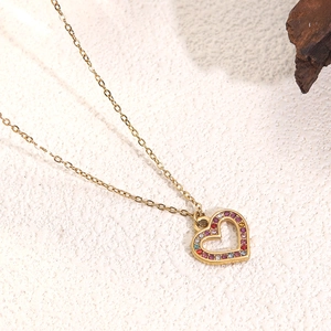 Detail view of heart pendant necklace in gold finish with colorful inlaid crystals