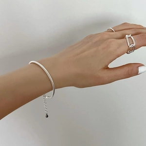 Close-up of a 925 sterling silver heavy snake chain bracelet and matching minimalist rings