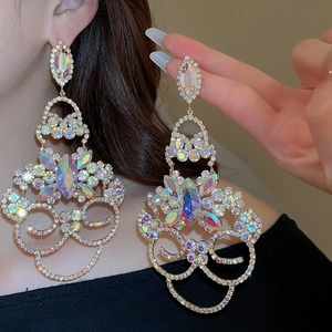 Détail macro de grandes boucles d'oreilles fleur à pompons avec strass colorés sur argent
