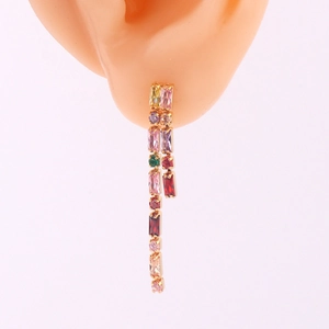 Macro detail of long tassel earrings with multi-colored crystals and gold plating