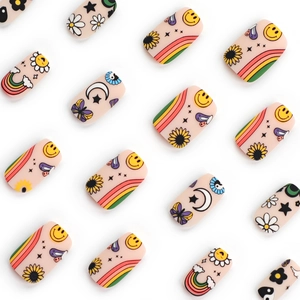 Cute cartoon press-on nails with smiley faces, rainbows and flowers on nude base
