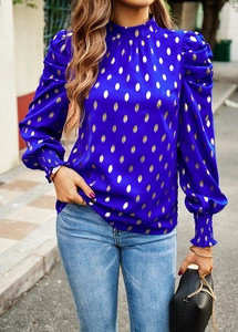 Detail of blue polka dot satin blouse with high neck and puffed sleeves in city street