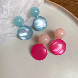Detailed macro view of geometric resin drop earrings in iridescent blue and pink finishes