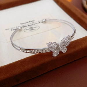 Macro shot of silver butterfly cuff bracelet with zircon stones on a dark velvet box