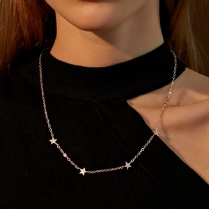 Dettaglio di ciondoli a forma di stella con micro-diamanti su una catena d'argento