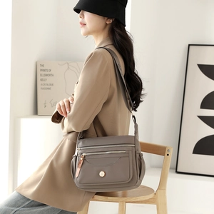 Taupe waterproof nylon crossbody bag with multi-zipper pockets and adjustable strap