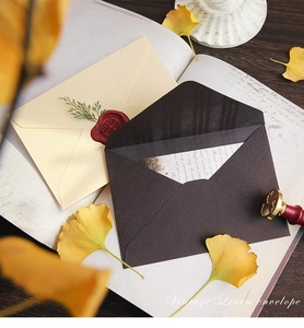 Detail of vintage linen texture envelopes with classic red wax seals on old book pages