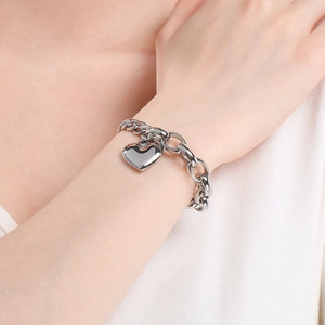 Close-up of heart charm bracelet with chunky chain link and toggle clasp in silver finish