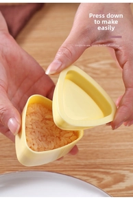 Primo piano del riempimento di riso bianco in uno stampo per sushi triangolare giallo