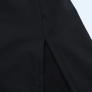 Gros plan sur la fente latérale et les coutures denses de cette robe moulante noire