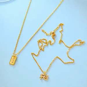 Detail van de gouden FE letter hanger en hemelse hangers kettingen met zirkonia