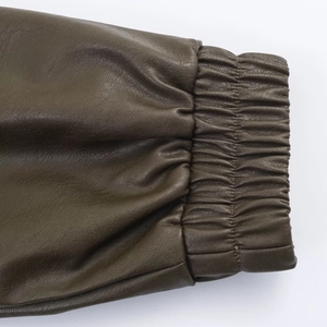 Detail der Bomberjacke in Dunkelolivgrün aus Kunstleder mit elastischem Ärmelbündchen