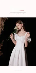 Detail of white satin dress with square neckline, bow knot, and pearl embellishments