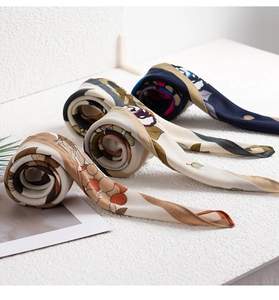 Detailed view of three rolled silk scarves featuring artistic geometric patterns and prints