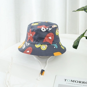 Détail d'un chapeau de soleil gris pour enfant avec motifs monstres et cordon ajustable