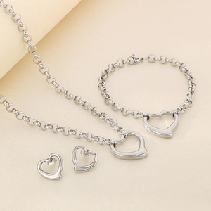 Macro shot of silver stainless steel jewelry set featuring hollow heart pendants and chain