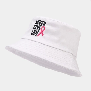 Close-up of NEVER GIVE UP embroidery and pink ribbon on white cotton bucket hat