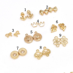 Golden alloy nail art charms collection featuring mini crown, bow, and anchor shapes