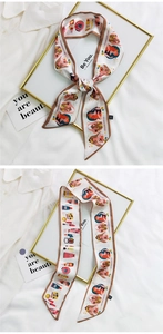 Close-up of cream scarf with girl illustration and cosmetic patterns on fabric