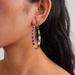 Detail of silver hoop earrings with colorful baguette-cut rainbow cubic zirconia stones
