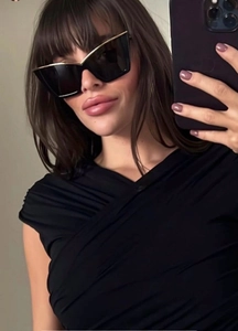 Detailed selfie showing black cat-eye sunglasses with elegant gold metal brow decoration