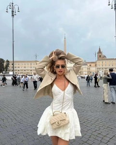 Détail d'un blazer beige et d'une robe en dentelle blanche avec sac matelassé