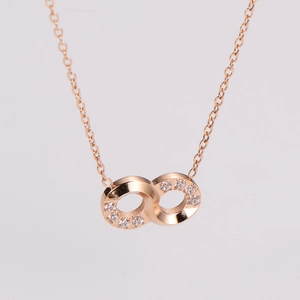 Macro detail of rose gold infinity necklace pendant with sparkling cubic zirconia accents