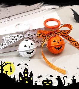 Detail of Halloween pumpkin bells with orange and white ribbons and spooky patterns
