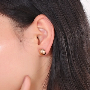 Macro view of 10mm rose gold dome stud earring worn on ear showing mirrored metal finish