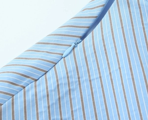 Close-up of fine light blue and white stripes with a hidden zipper on woven fabric