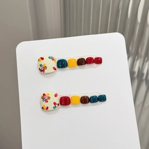 Floral press-on toenails featuring colorful hand-painted flowers and glossy solid colors