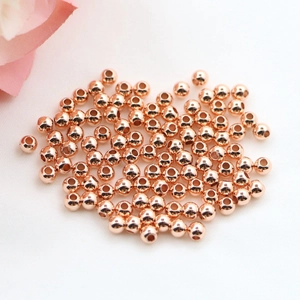 Close-up of loose round rose gold solid beads for DIY jewelry making and handmade crafts