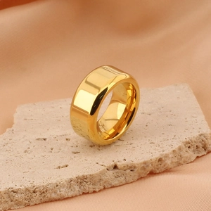 Polished gold titanium steel ring displayed on stone with silk fabric background