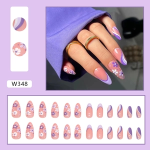 Detail of purple floral almond press-on nails with white petals and wavy line designs