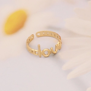 Close-up of golden stainless steel open ring with creative Love script design