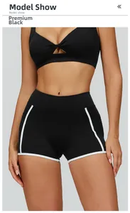 Detail of high-waisted black yoga shorts with white contrast trim and side pockets