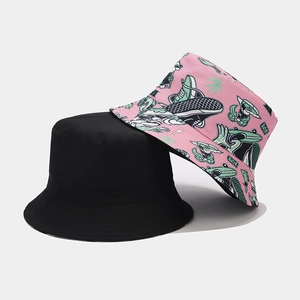 Detail of reversible bucket hats in black and pink with stylish graffiti print patterns