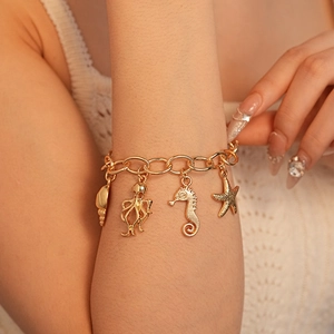 Golden ocean charm bracelet featuring shell, octopus, seahorse and starfish pendants