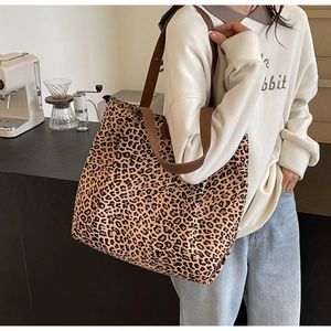 Détail d'un cabas en toile léopard avec bandoulière marron dans un décor de café