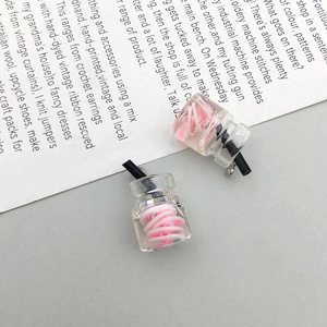 Close-up of miniature transparent resin bear bottles with fruit slices and straw detail