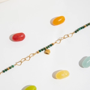 Détail du collier chaîne cœur en or 18 carats avec perles vertes et pendentif 3D