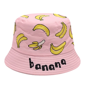 Détail d'un chapeau bob en coton rose avec motifs de bananes jaunes et texte brodé