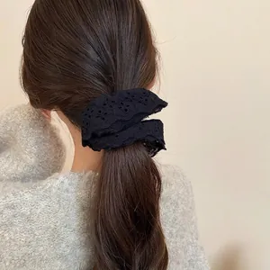 Elegant double-layered black lace scrunchie with intricate hollow embroidery on hair